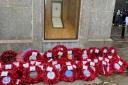 Poppy wreaths below the war memorial
