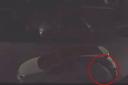 Footage shows a figure working their way around the car