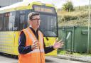 Mayor Andy Burnham standing in front of the newest tram