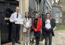 Left to right: A Downing Street security guard accepts the petition from Helen Rowlands, representing the Greater Manchester Coalition of Disabled People; Debbie Abrahams, MP for Oldham East and Saddleworth; and Pete Marshall, also GMCDP