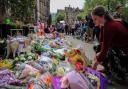People lay flowers outside the Town Hall in Albert Square, Manchester