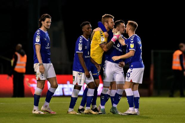 Laurie Walker celebrates with Latics team-mates after saving the last penalty during the Caraboa Cup clash with Accrington