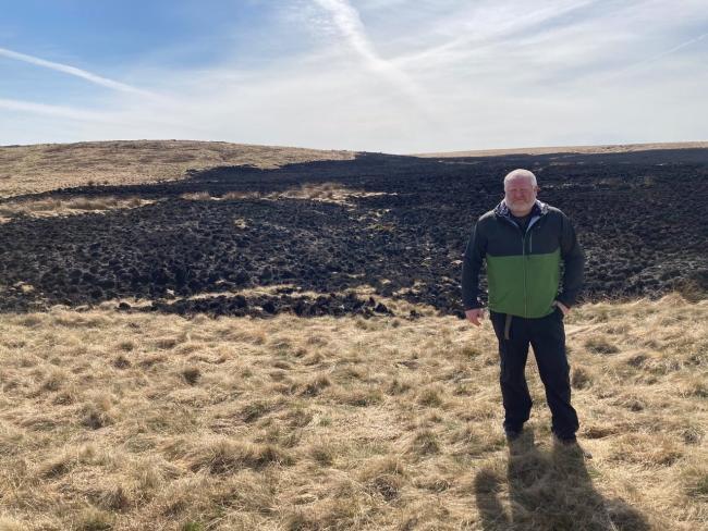 National Trust West Yorkshire operations manager, Craig Best, next to blackened moorland at Marsden Moor last April