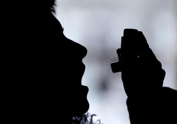 The Oldham Times: Silhouette of a person using an inhaler. Credit: Canva