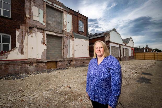 The Oldham Times: Cllr Amanda Chadderton standing showing the rear extensions demolished