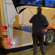 The smashed windows of the Anthony's Travel coach being assessed
