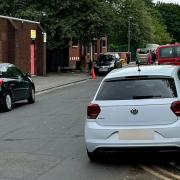 Cars parked on double yellow lines near the school