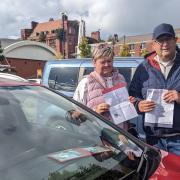 Martin and Jackie standing with their blue badge and parking fine letters in an unrelated car park, as they pledged not to return to Elk Mill