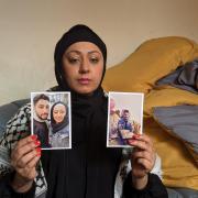 Afshan Abubakar, holding photos of her fiancé Hani