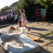 Hanan (right) and Rayan photographed by their mother, Ruba, while playing with a dog in their neighbours garden