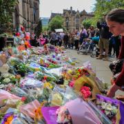 People lay flowers outside the Town Hall in Albert Square, Manchester