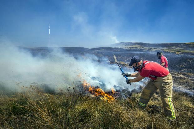 BATTLE: The firefighters work to extinguish the flames on the moors